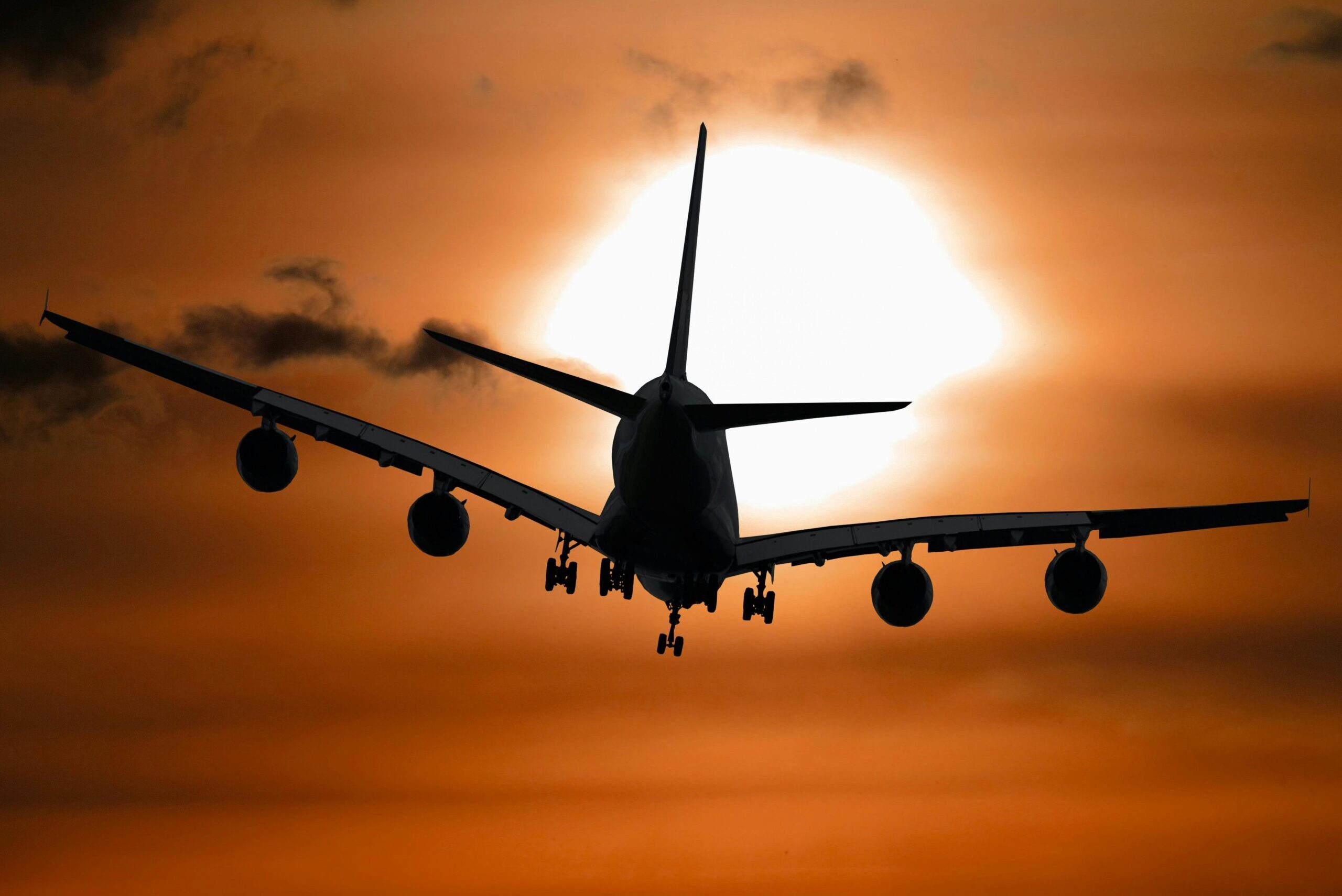 plane flying with a sunset in the background.